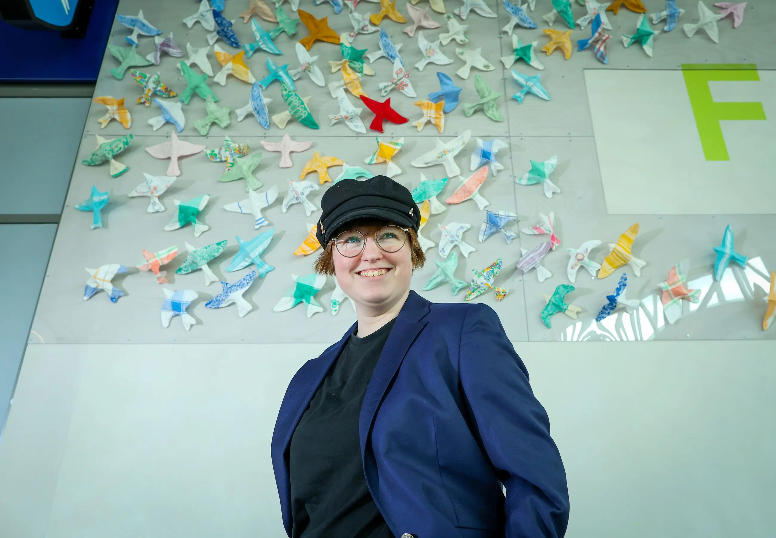 Anna Warwick Photograph A photograph of artist Anna Warwick in front of her artwork at Belfast Grand Central Station.
