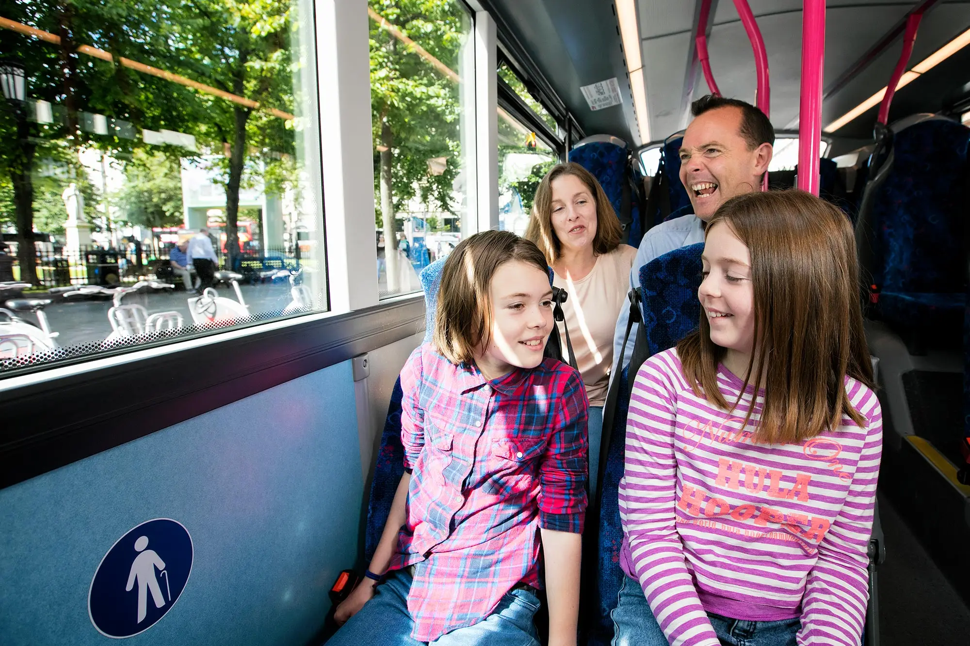 A photograph of a family travelling on a Belfast Metro bus.