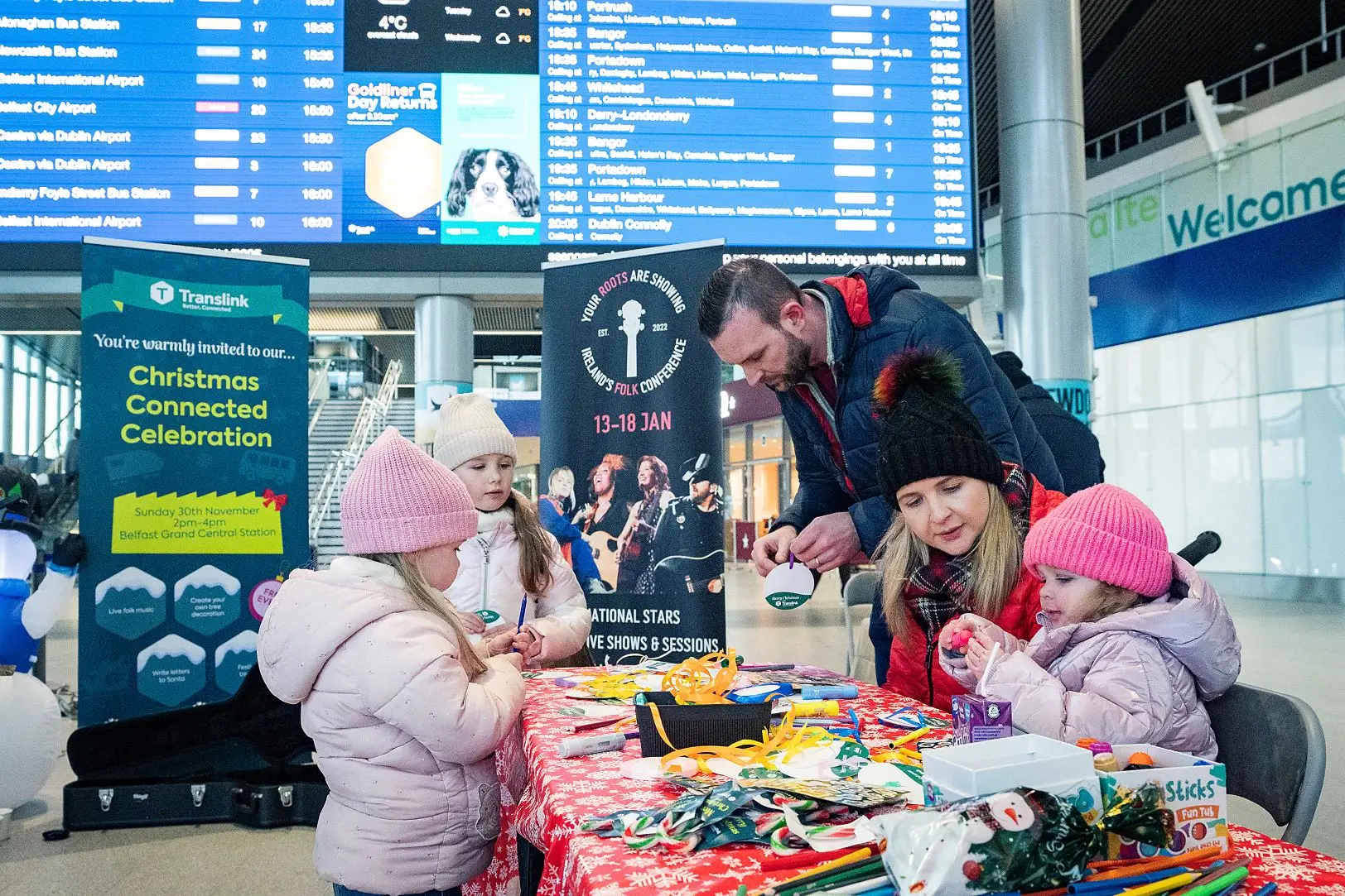 A photo of adults and children taking part in Translink's Christmas Stuff a Bus campaign.