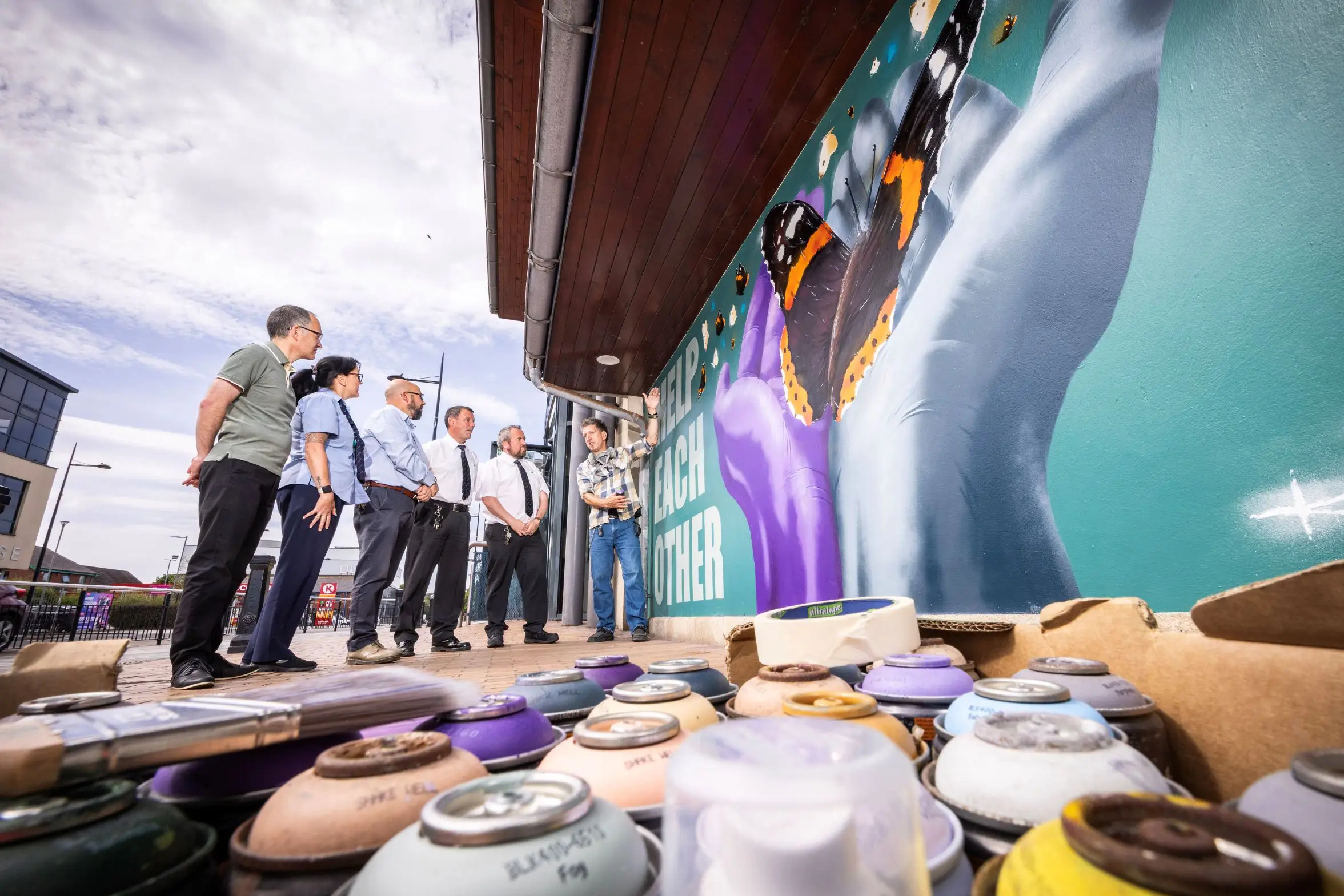 Downpatrick Mural 1 Artist Kieron Black showing his new mural at Downpatrick Bus Station to Translink staff.